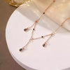 Rose gold necklace with black gemstones on a white surface