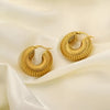 Close-up of chunky ribbed gold hoop earrings on satin fabric for luxury effect