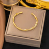 Gold bamboo bracelet displayed on gift box, perfect for unisex fashion and gifting