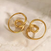 Pair of gold hoop earrings on a textured beige surface