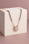 Necklace with a floral pendant on a white box against a pink background