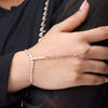 Hand wearing a delicate bracelet with a dark background