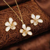 Flower-shaped jewelry set with gold and white flowers on a brown textured background