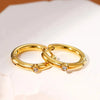 Gold hoop earrings with clear crystal stones displayed on luxury mirror tray – modern minimalist jewelry.