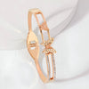 Rose gold bracelet with butterfly design on a light background